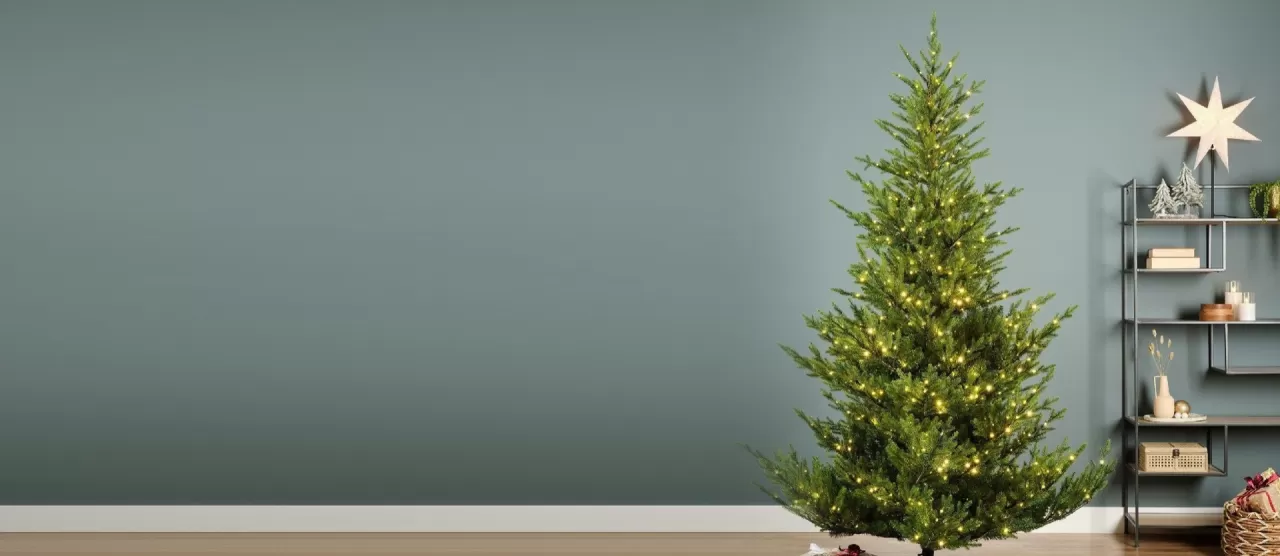 Albero di Natale Norway Spruce di Kaemingk con micro LED accesi, in un soggiorno con pareti grigio-verdi